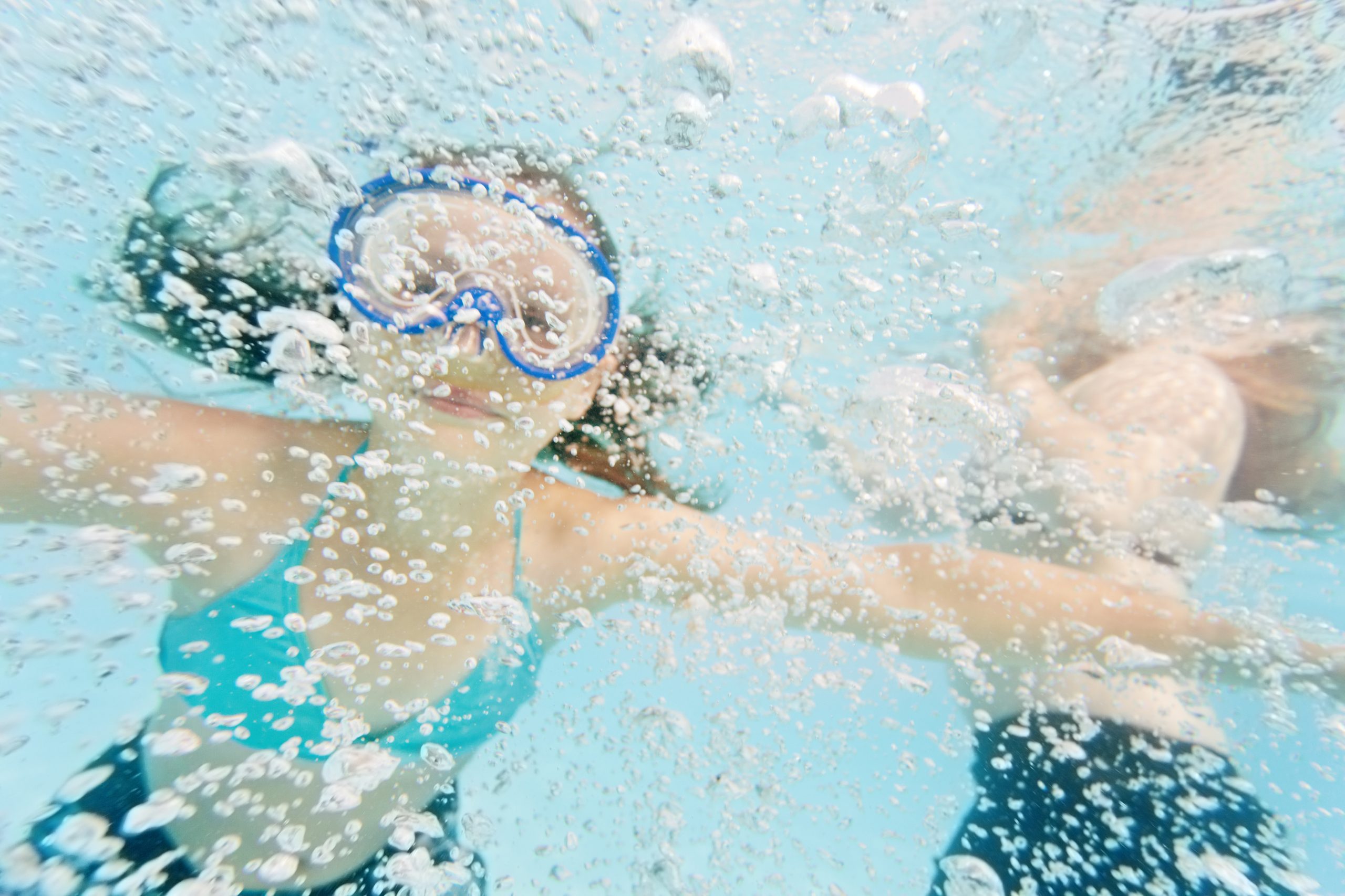 Barn med cyklop under vattnet i en pool